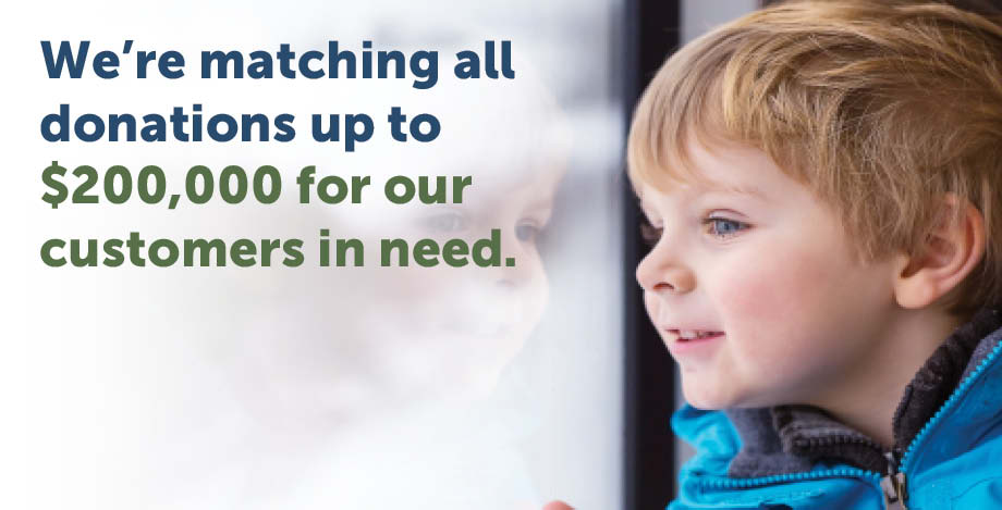 A small boy looks out a window. The image reads "We're matching all donations up to $200,000 for our customers in need."